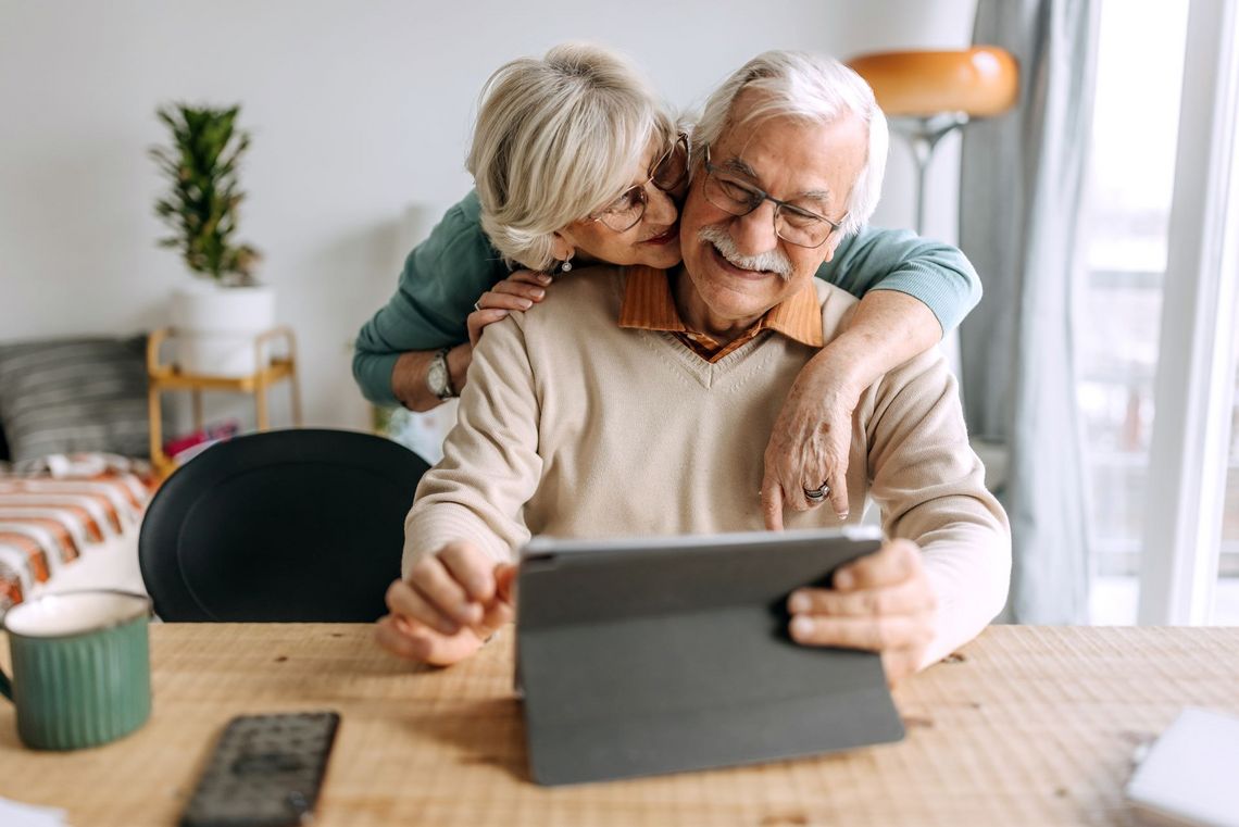 Älteres Ehepaar am Küchentisch mit Tablet