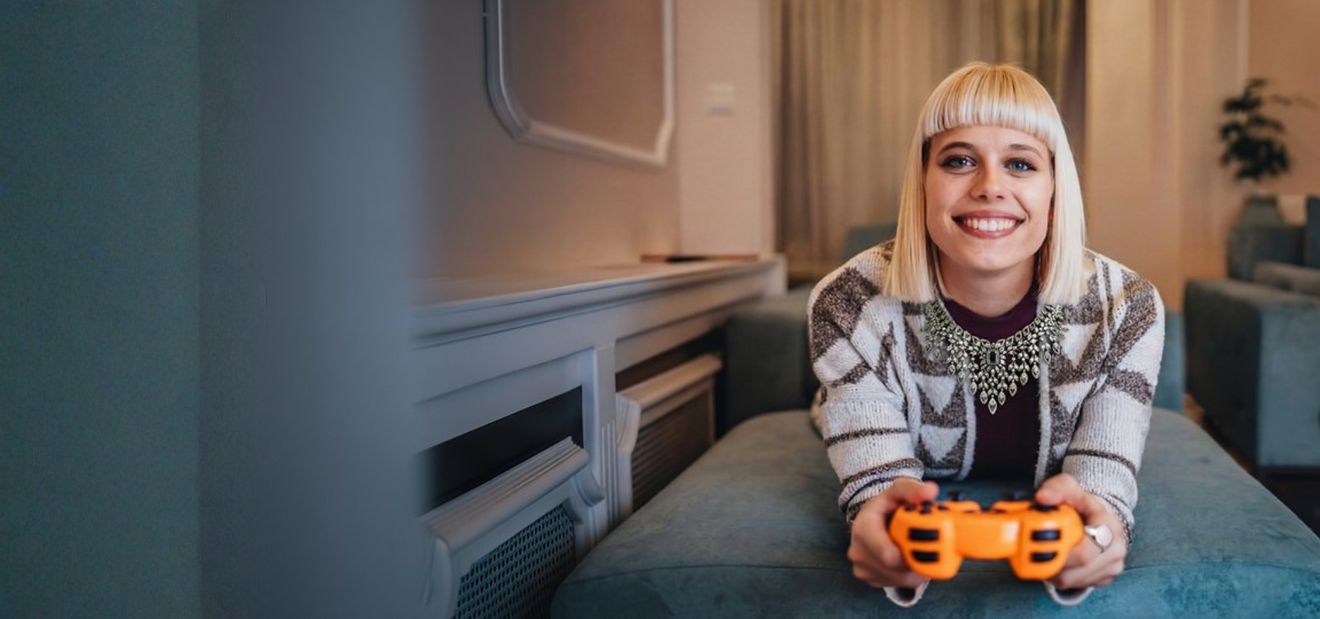 Junge blonde Frau mit Gaming-Controller in der Hand