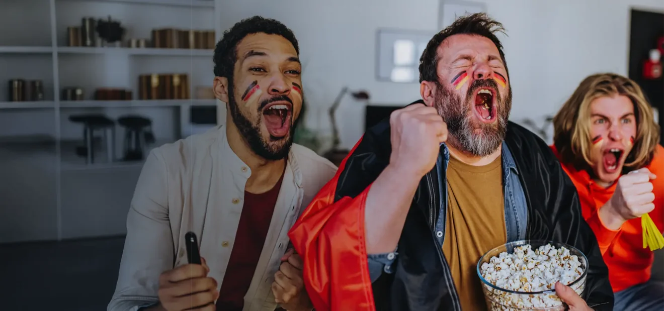 Zwei Fußballfans jubeln vor dem Fernsehr